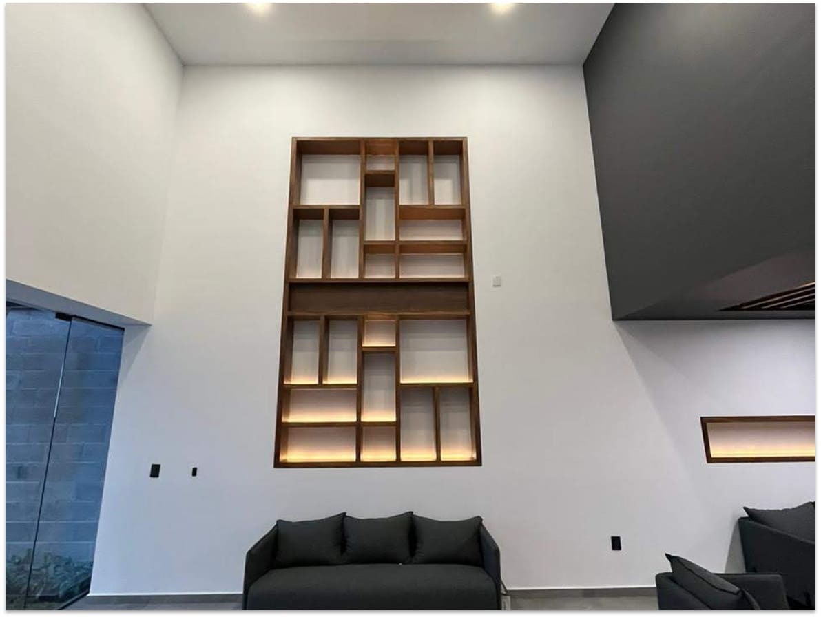 Nicho empotrado de madera con compartimentos geométricos de diferentes tamaños, iluminación LED integrada y acabado en madera natural